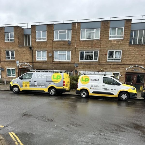 Two London Plumbing Company vans outside flats in South London
